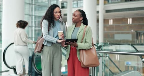 Tablet, planning and business women in the office for a collaboration project by the escalator