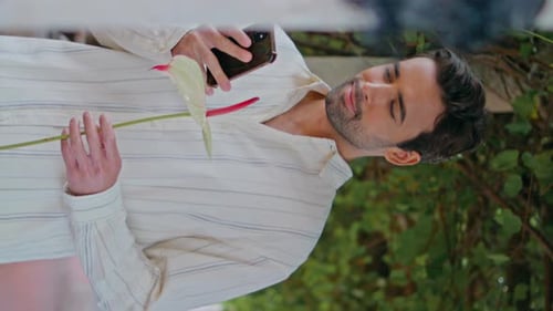 Enamoured Guy Reading Sms Phone at Alley Vertical Closeup Man Holding Flower