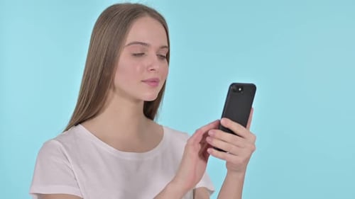 Young Woman Reacts with Shock to Smartphone Content