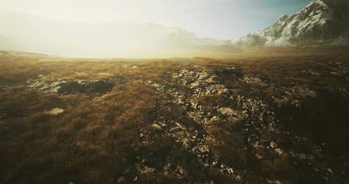 Majestic Rocky Landscape at Dawn with Mountains Under Soft Golden Light