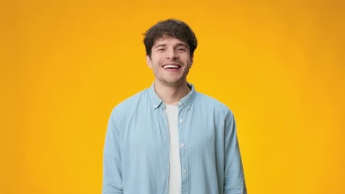Un homme sourit sur un fond jaune vif capturé dans des séquences de haute qualité pour une utilisation vidéo en résolution