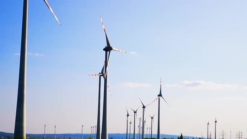 Blätter von Windmühlen drehen sich langsam im Wind. Blick aus dem niedrigen Winkel auf die Windturbinen