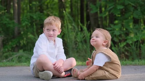 Zwei Jungen sitzen bequem auf dem Boden und sprechen miteinander
