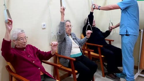 Elderly People Exercising Arms with Pulleys in Nursing Home