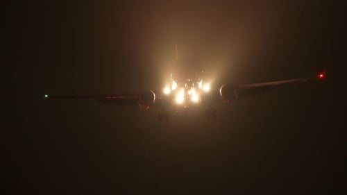 An airliner on final approach to Los Angeles International Airport at night in slow motion.