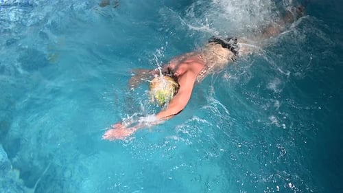 Vista submarina de un nadador profesional entrenando en una piscina, 120 fps, cámara lenta, RAW