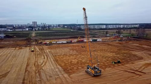 Una grúa que deja caer un peso en una obra de construcción para una compactación dinámica del suelo: vista aérea