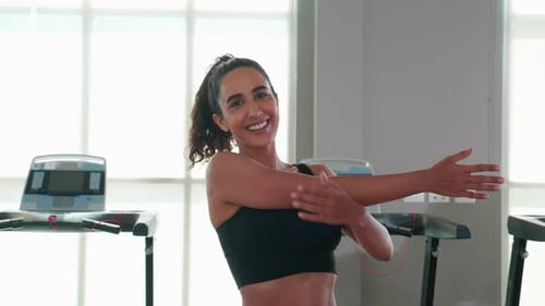 Beautiful young caucasian woman workout with warm up and stretch muscle arm in fitness gym.