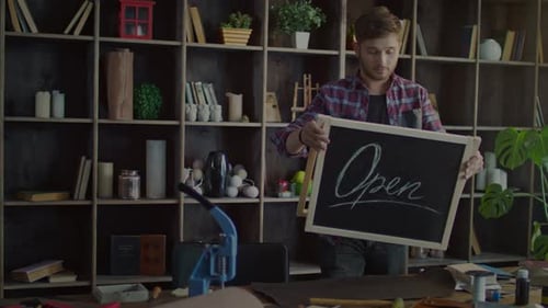 Dueño de una pequeña empresa con el letrero abierto en Creative Office. Abierto Young Man