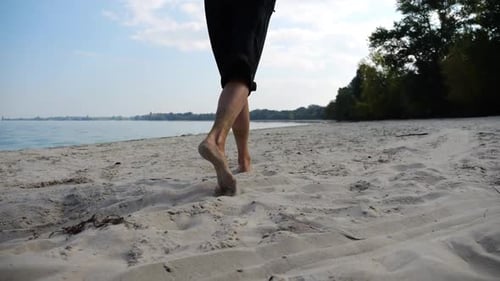 Bare Feet of Adult Woman Jogging on Sand at the Beach with Seascape at Background Female Legs