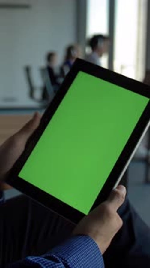 Vertical of Hispanic Businessman Holding a Black Tablet Computer with Green Screen