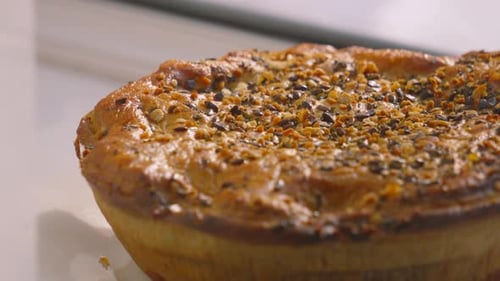 Pan Across Whole Chicken and Mushroom Pie with Various Seeds on Top Ready to Cut Portions and Serve.