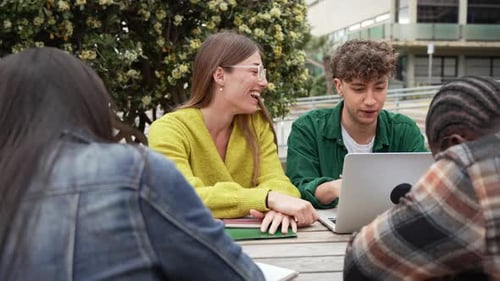 Students Using Laptop for Exams Preparation Sitting Outdoors in the University Campus Park