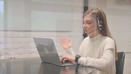 Young Adult Woman Working at Computer with Headset