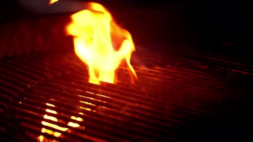 Extreme Nahaufnahme des schwarzen Barbecue-Grills bei Nacht, beim Aufheizen des Grills zum Braten von Fleisch