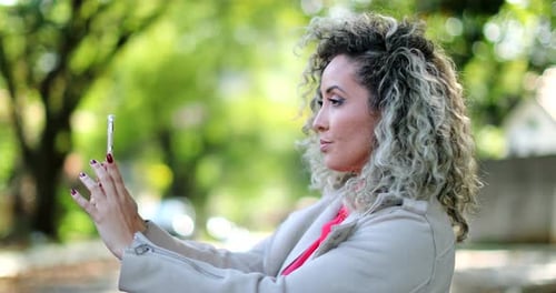 Woman with Curly Hair Posing for Selfie Outdoors