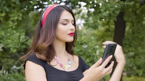 Stylish Woman Taking Selfie in a Green Park