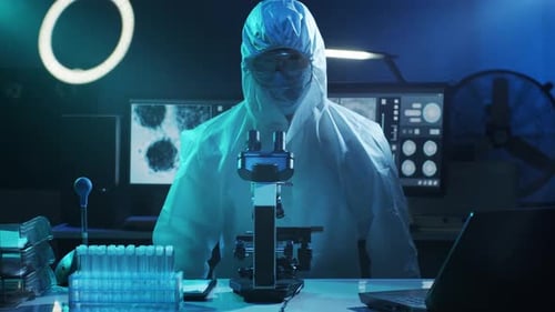Scientist Using Microscope in Blue Lit Laboratory