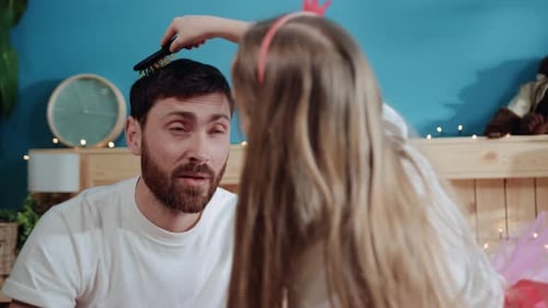 Playful Daughter Combs Father's Hair in Bedroom