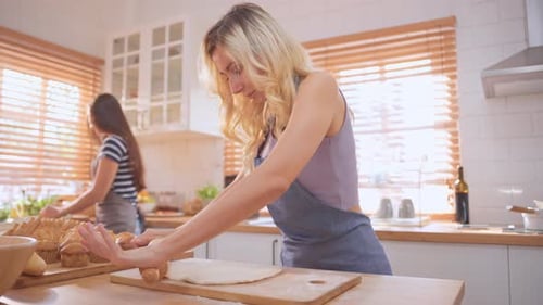 Caucasian young woman baking bakery with friend in kitchen at home.