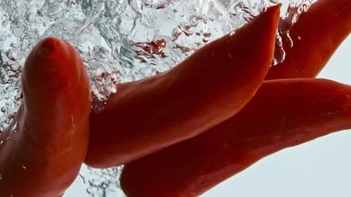 Red Chili Peppers Falling into Water Bubbles