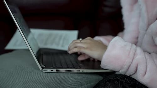 Woman Types on Laptop Indoors in Relaxed Setting