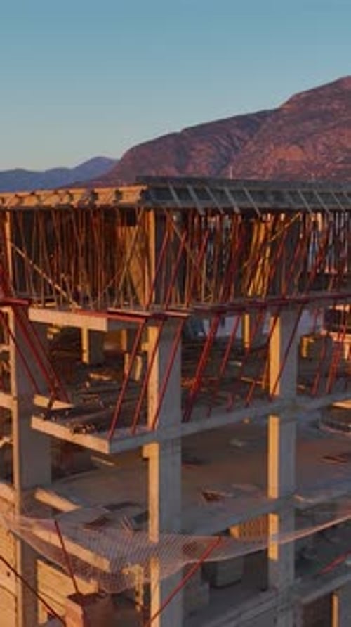 Vertical Aerial View of Structure Under Construction with Visible Floors and Materials Stacked
