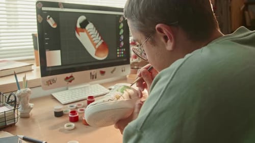Young Adult Painting a Custom Design on Shoe