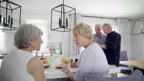 Seniors Friends Talking and Relaxing in Modern Kitchen