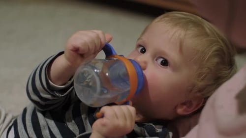 Baby Drinks from Sippy Cup While Lying Down