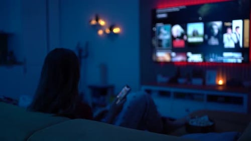 Woman on Couch Using Smartphone at Night