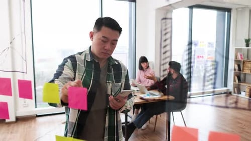 Businessman Brainstorming with Sticky Notes in Office