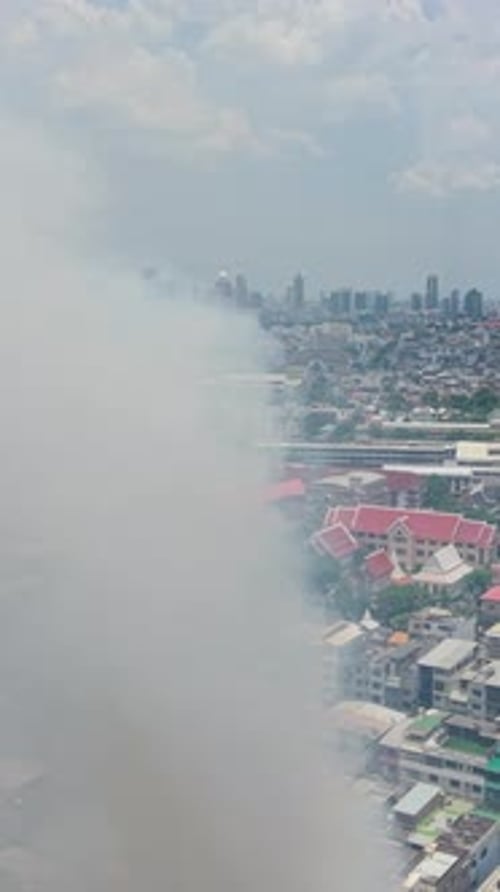 Smoke Rises From a Raging Fire That Consumes a Building Amid Bangkok's Sprawling Cityscape