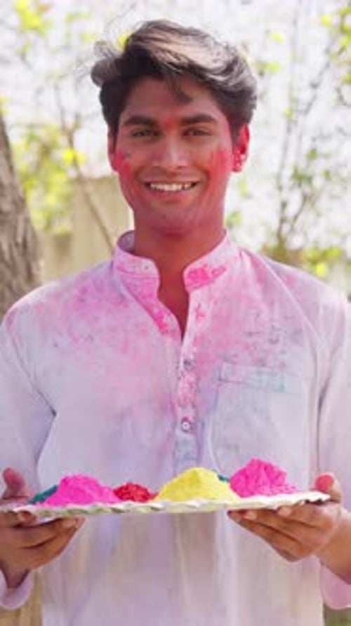 Happy Young Man Celebrates Holi with Colorful Powder