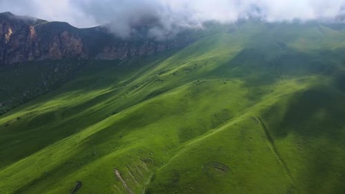 Serene Green Mountains with Rolling Hills and Clouds a Display of Natures Beauty