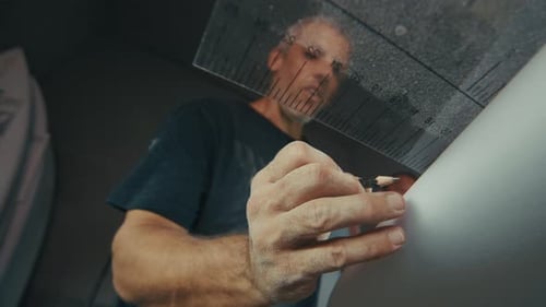 Surf factory. Adult male shaper creates the surfing board on the factory