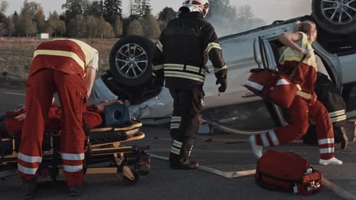 Car Crash Traffic Accident: Paramedics and Firefighters Rescue Injured Trapped Victims. Medics give