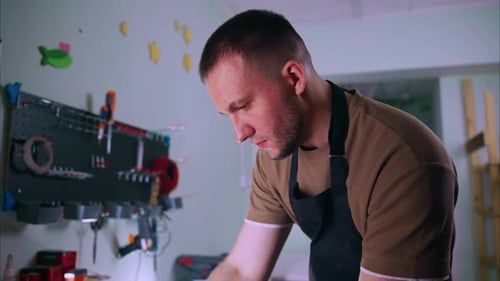 Craftsman Examining Wooden Planks in His Workshop