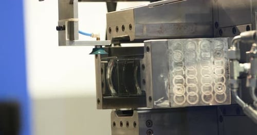 Injection Molding Machine Ejecting Plastic Product During Operation In A Manufacturing Company. clos
