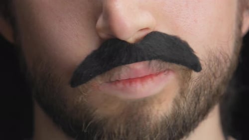Man with fake mustache making facial expressions, close up detail