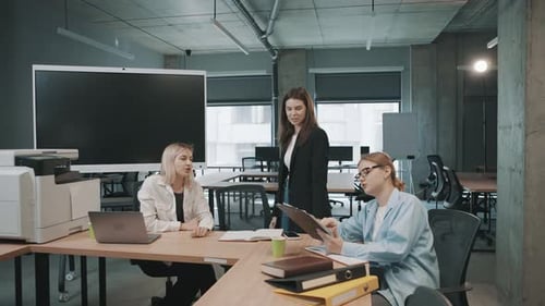 Colleagues meet in office to discuss project details and share ideas for effective teamwork