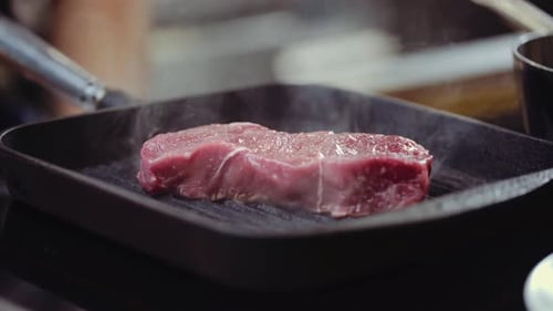 Pressing Steak on Hot BBQ Grill Pan