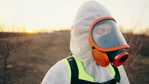 Person in Hazmat Suit Wearing Orange Gas Mask