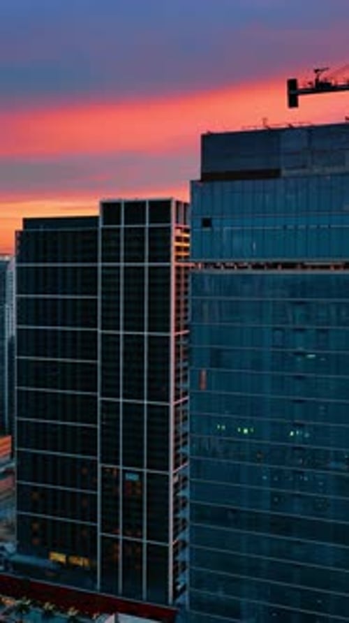 Pink light of sunset reflecting in the mirror facades. Architecture of Miami, Florida from top.