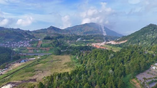 Drone video capturing the scenic highlands of Dieng Plateau, featuring lush agricultural terraces,