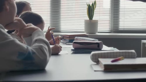 Children Working On Class Assignment in School Classroom