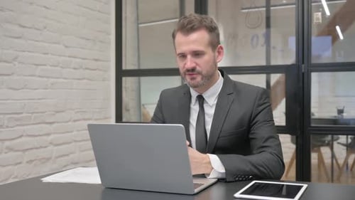 Businessman On Video Call At Office Desk