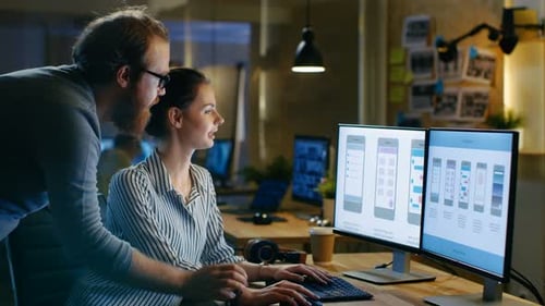 Female UX Architect Has Discussion with Male Design Engineer, They Work on Mobile Application Late