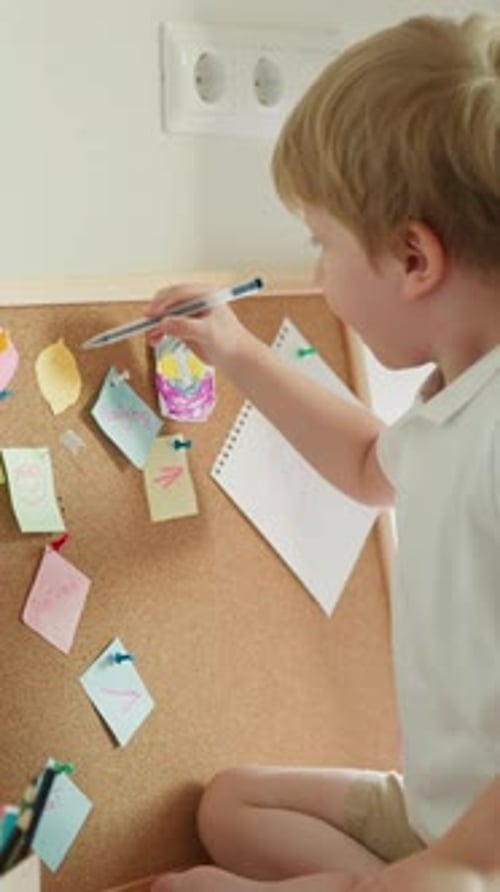 Blond Preschooler Draws with Ballpen on Piece of Paper