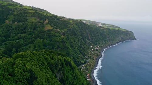 Volcanic Island Washing Ocean on Cloudy Day Drone View Dark Sea Waves Foaming